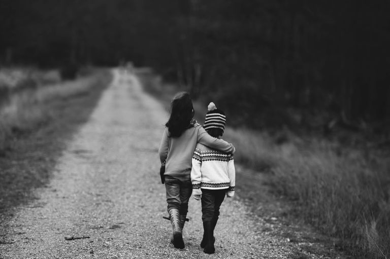 2 children walking while holding each other