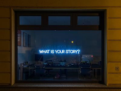 A neon sign that says what is your story