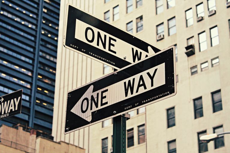 2 one way signs pointing in different directions