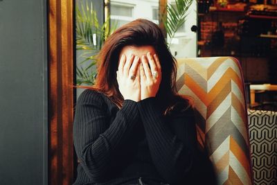 A woman covering her face in discomfort